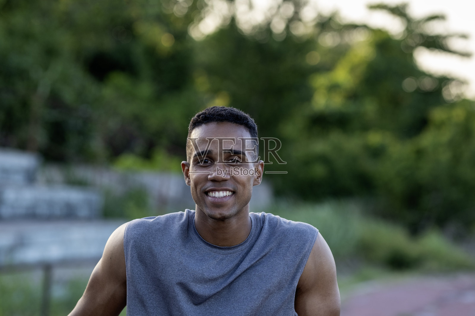 微笑的年轻男子在户外训练后放松的肖像照片摄影图片