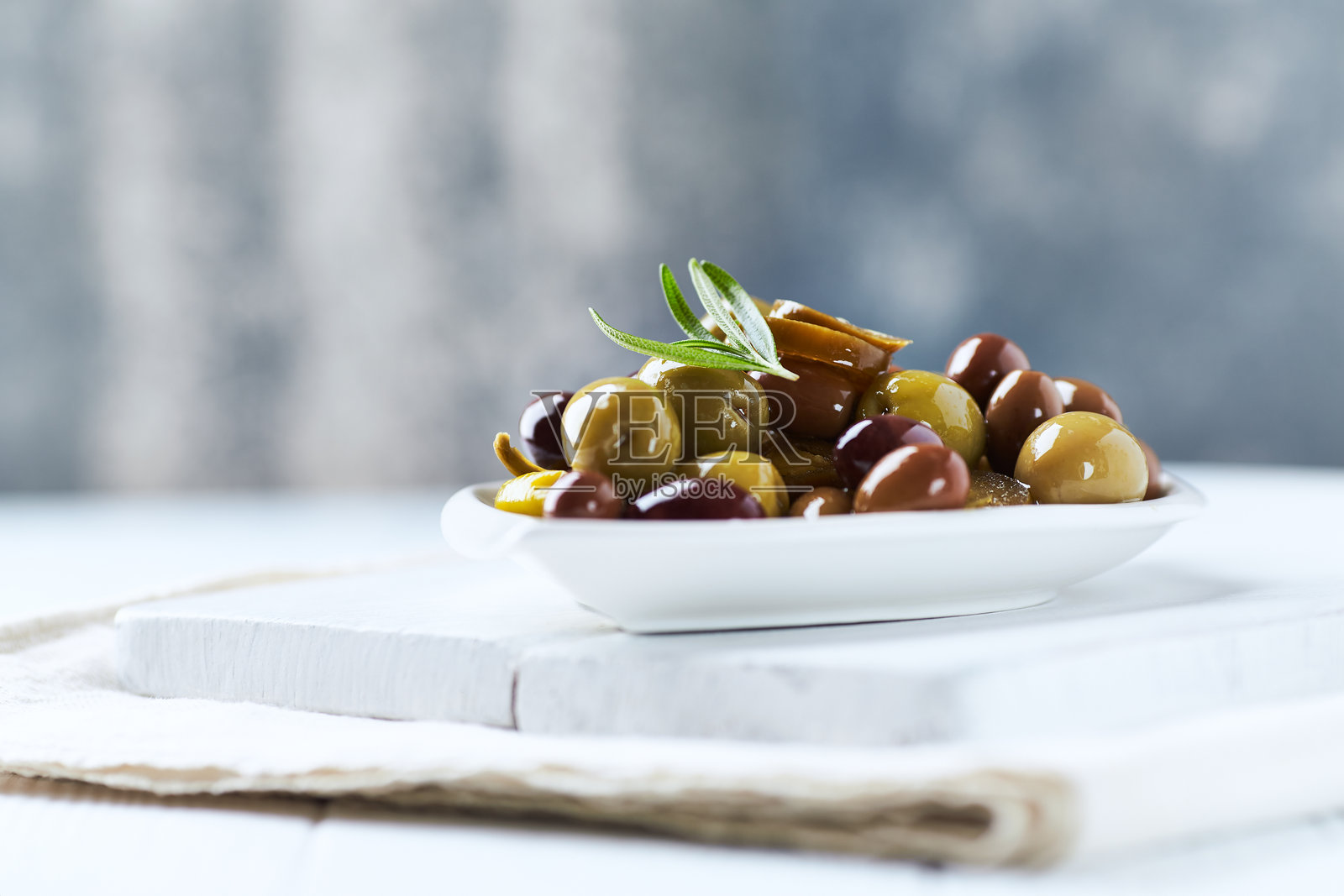 各种橄榄在明亮的木质背景上。特写。留白空间。照片摄影图片