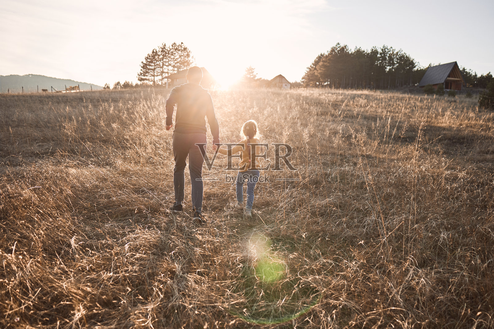 快乐的女孩在大自然中与父亲一起奔跑照片摄影图片