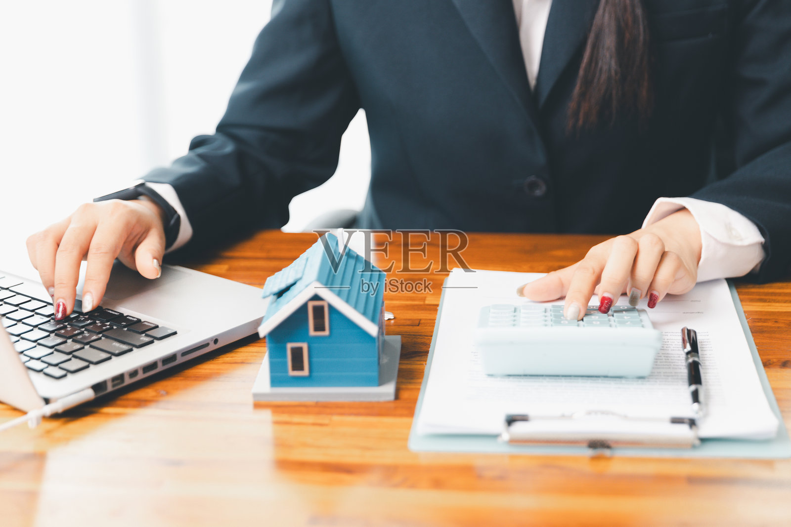 房贷专员使用计算器与房屋计划贷款房地产或物业。重要的是使用贷款计算器寻求房地产、金融保险建议，以确保为业务做出明智的财务决策。照片摄影图片