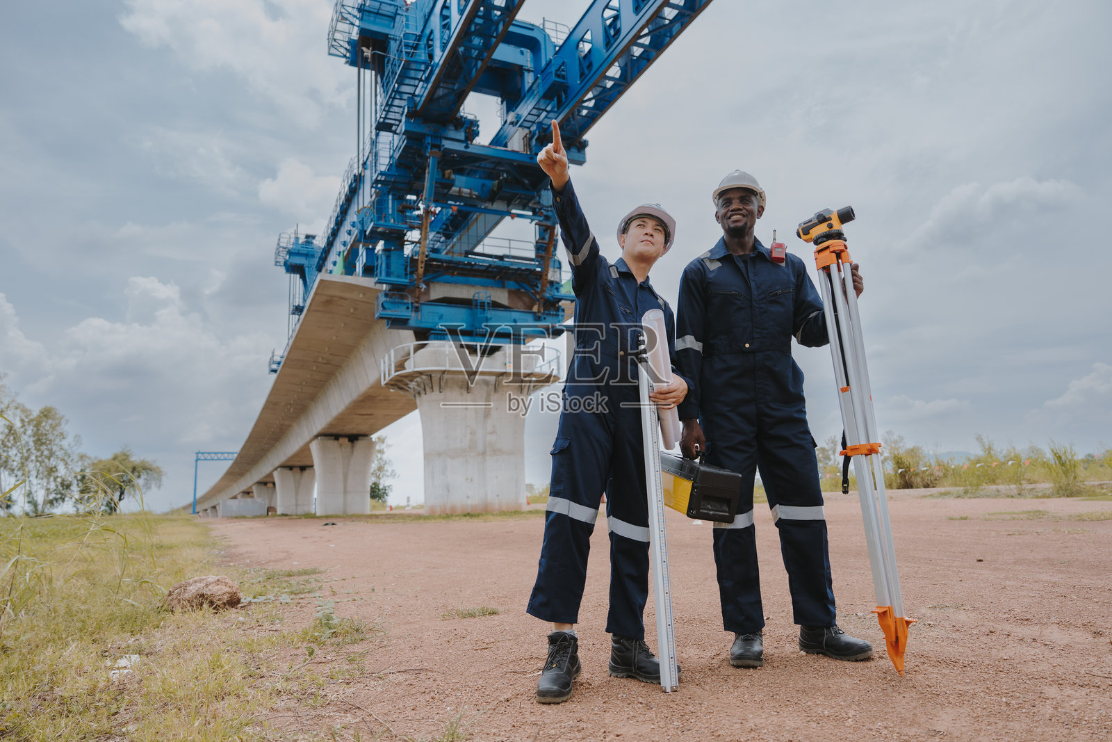 测量工程师在公路和高速铁路施工现场使用测量相机进行测量或进行安全检查。照片摄影图片