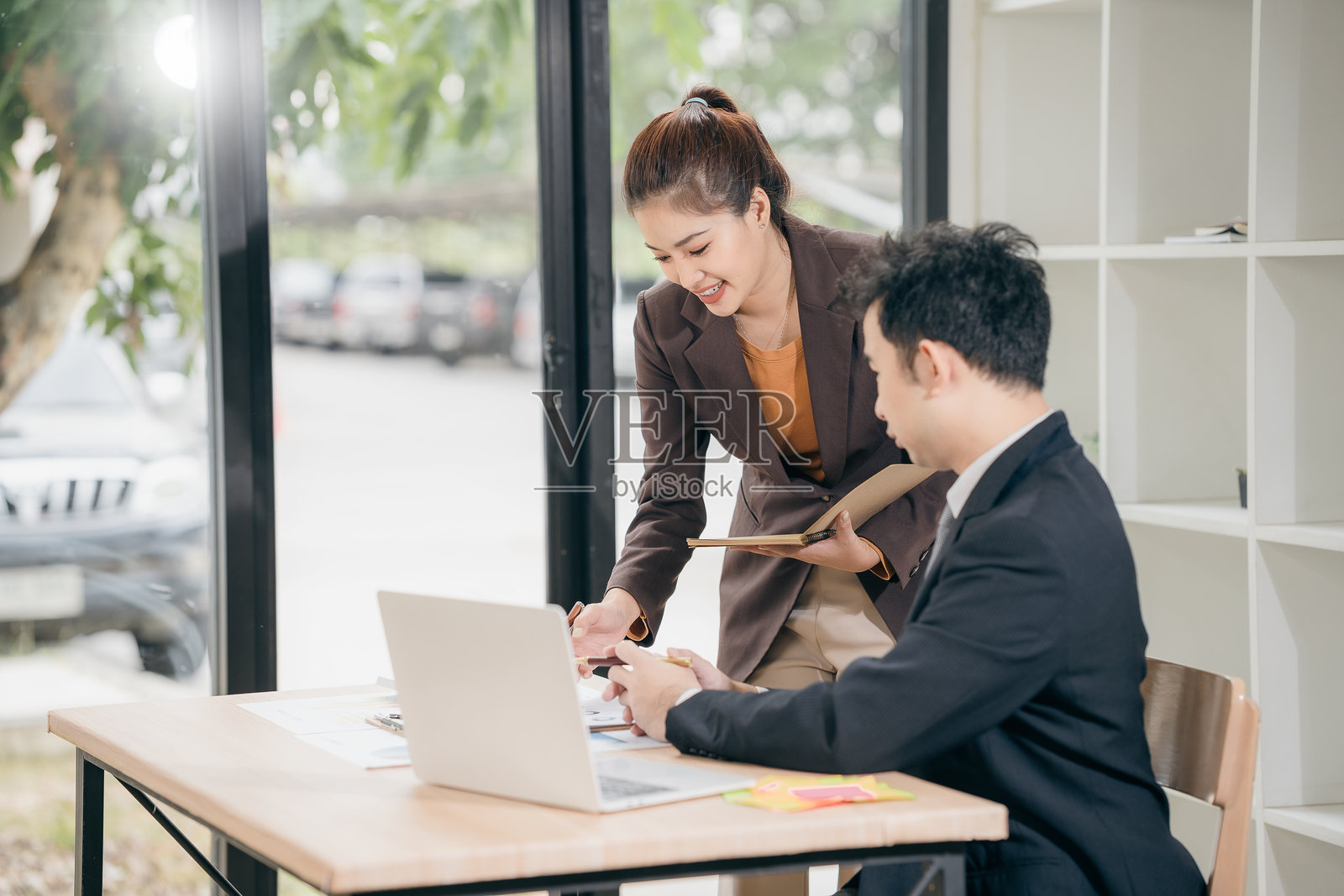 商务男女讨论显示成功团队合作成果的图表和图形，使用笔记本电脑进行商业战略规划和头脑风暴。照片摄影图片