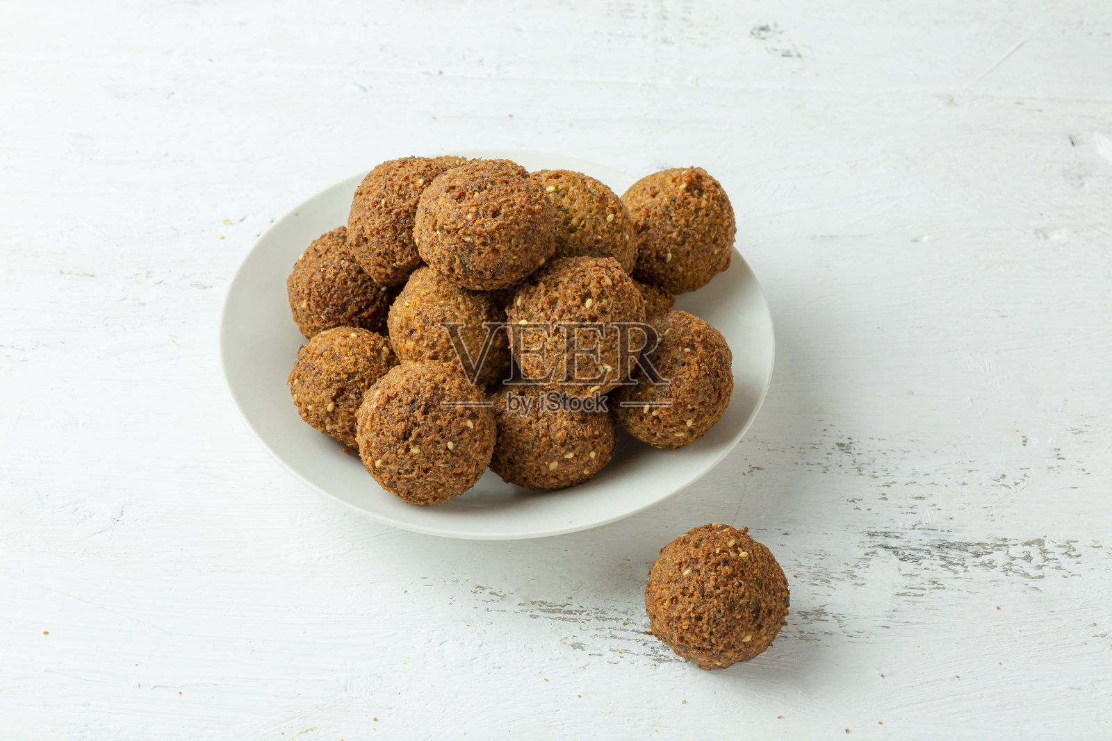 白色背景上的法拉费早餐盘，配有酥脆的饼和新鲜的配菜照片摄影图片