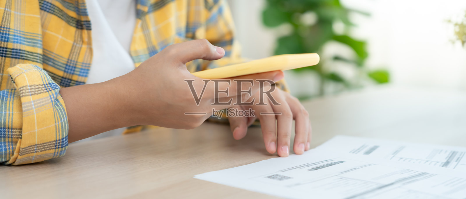 现代女性使用手机扫描条形码或二维码支付信用卡账单，收到文件发票后进行支付，电费支付，数字支付无需现金，科技，扫描。照片摄影图片