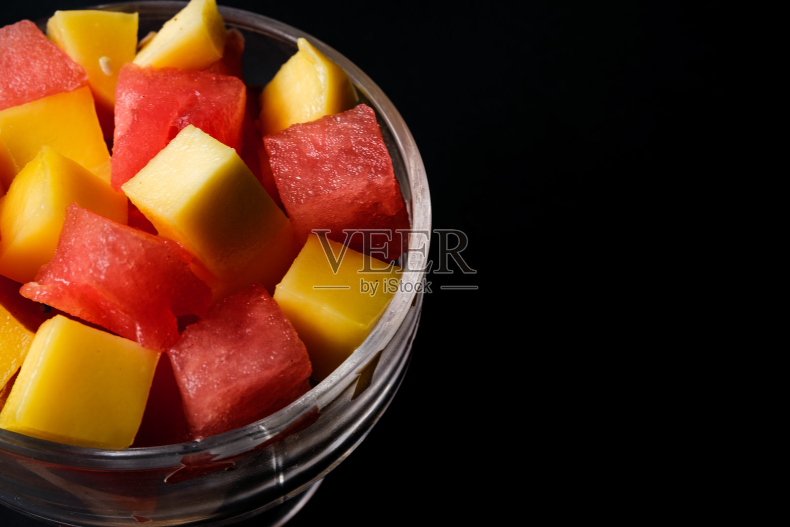 一碗新鲜健康的切块芒果和西瓜水果沙拉照片摄影图片