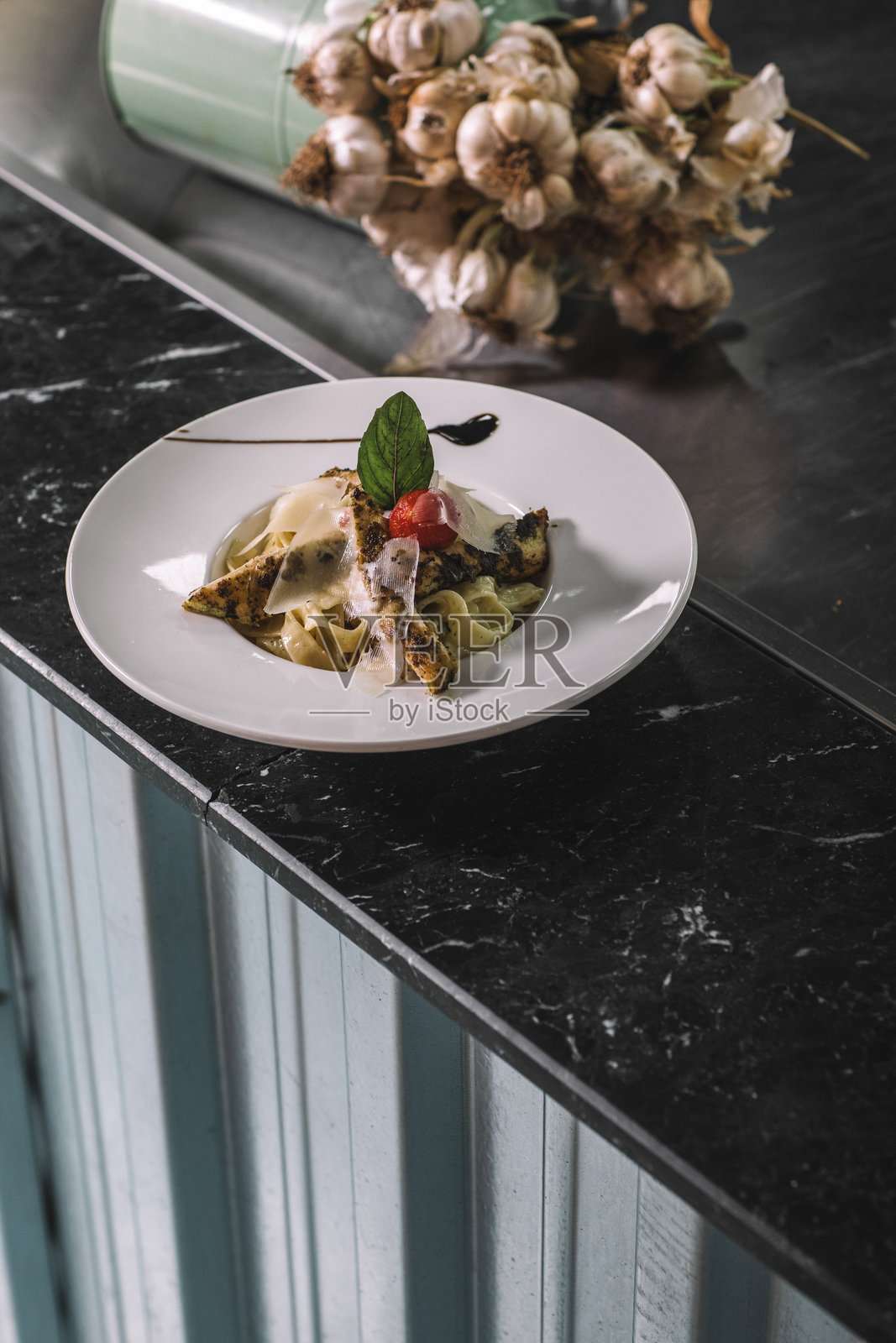 美味的宽带意面配鸡肉、西红柿和新鲜香草，意大利风格的意面搭配烤鸡、香草和番茄片照片摄影图片