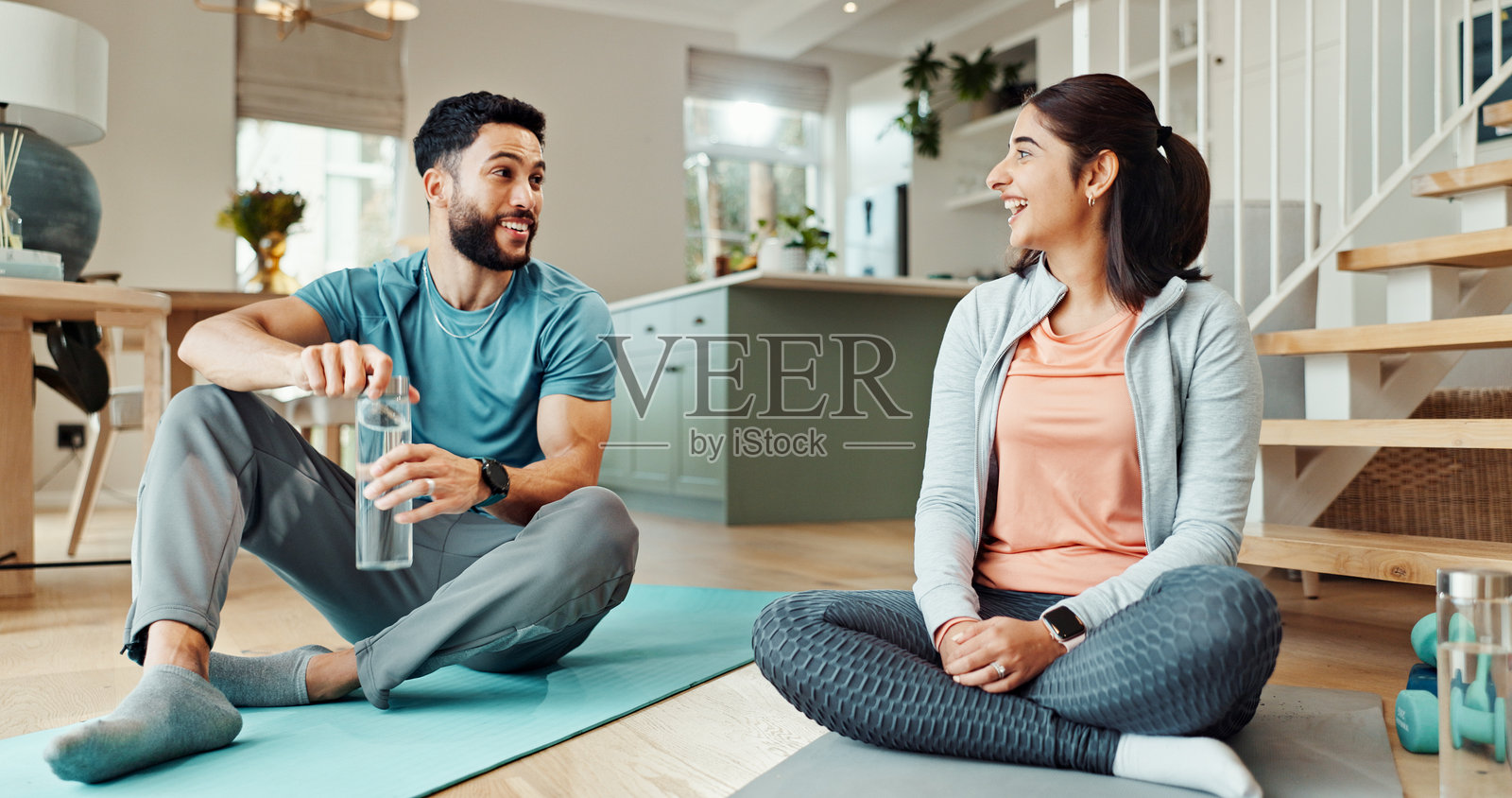 健身、微笑和水，夫妻在家中客厅共度时光，增进感情、健康或幸福。锻炼、补水或瑜伽，男女在公寓中保持平衡、关系或放松。照片摄影图片