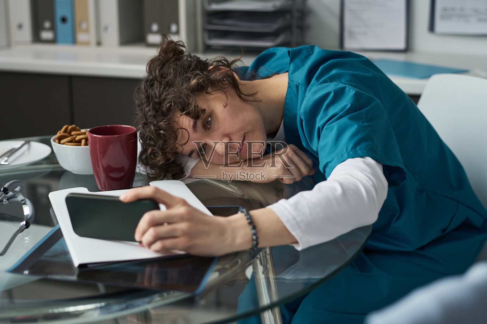 疲惫的医疗专业人员在休息时靠在桌子上休息照片摄影图片