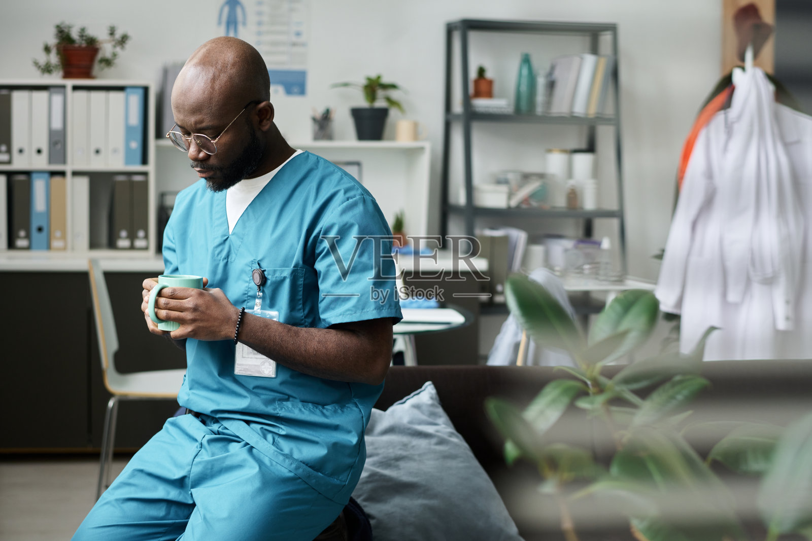 非裔美国医生在办公室喝咖啡休息照片摄影图片
