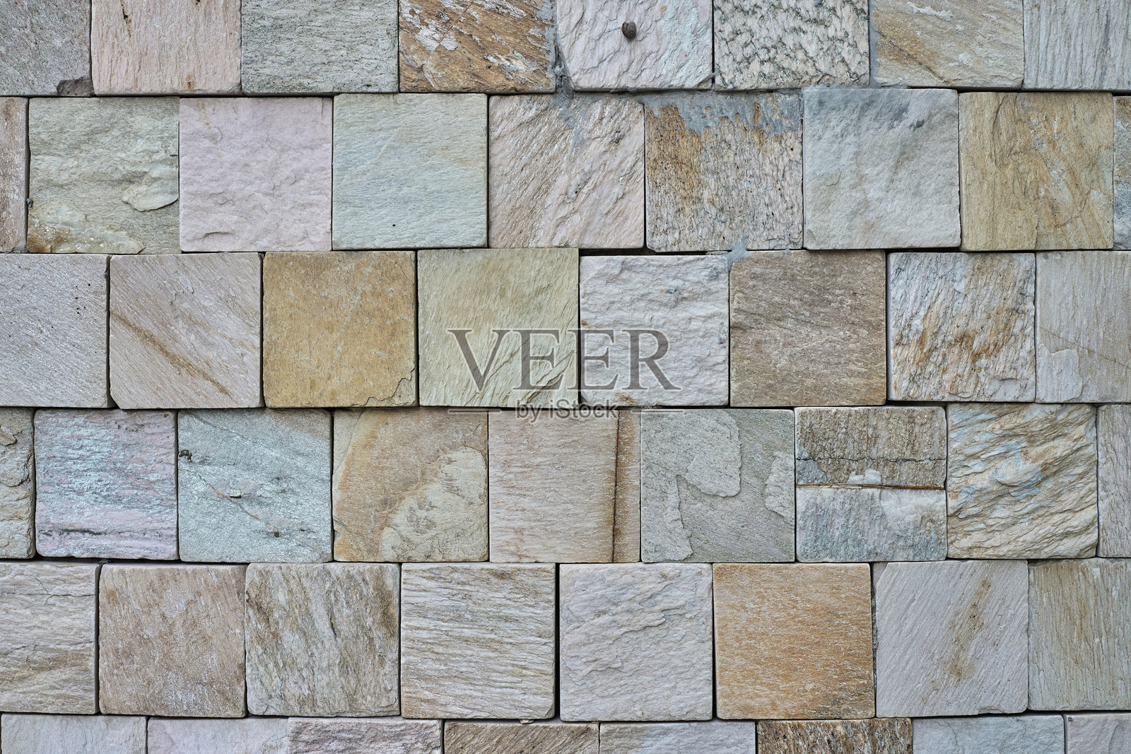 一面由不同颜色的方形石砖组成的纹理墙照片摄影图片