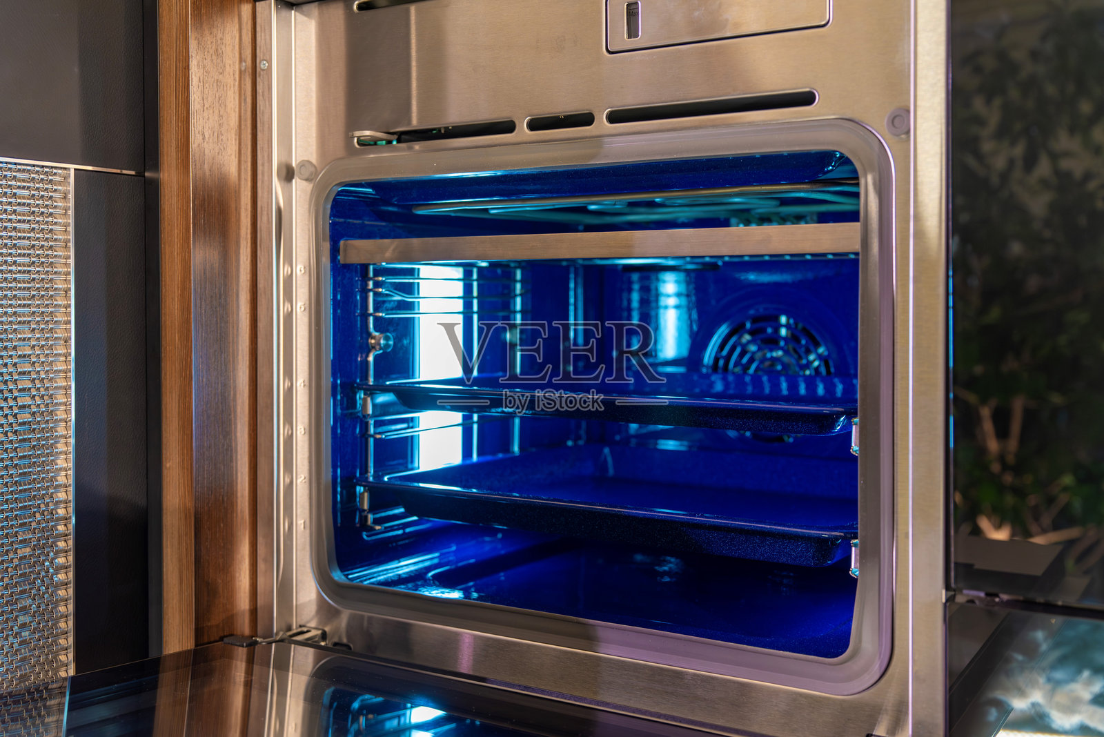 带有蓝色内部照明的不锈钢壁炉的斜视图照片摄影图片