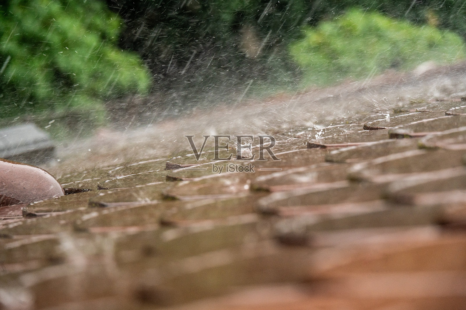 大雨拍打着屋顶瓦片照片摄影图片