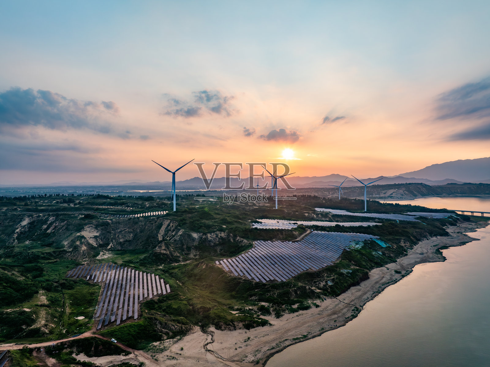 日落时分的太阳能光伏风车与风能照片摄影图片