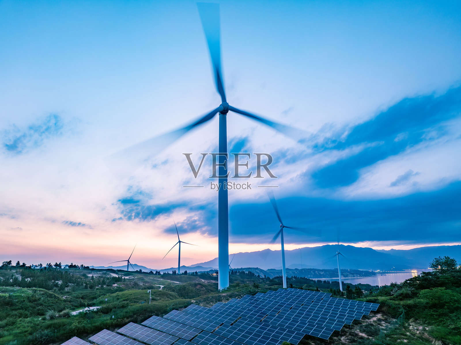 日落时分的太阳能光伏风车与风能照片摄影图片