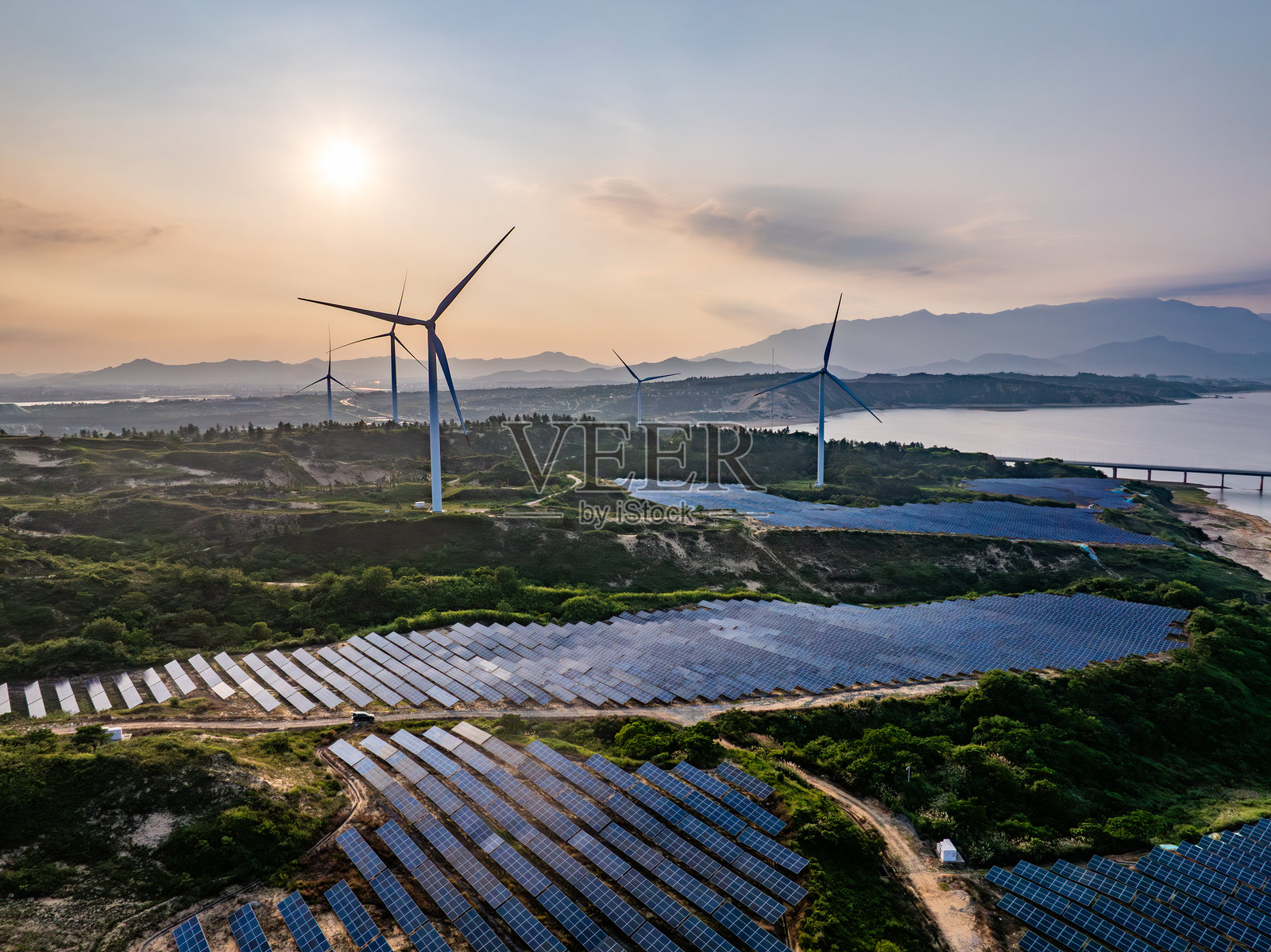 日落时分的太阳能光伏风车与风能照片摄影图片