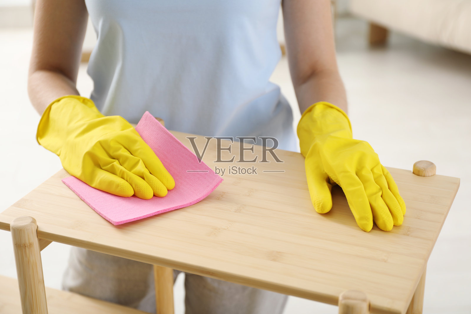 年轻女性在家中用抹布清洁木制架子，特写镜头照片摄影图片