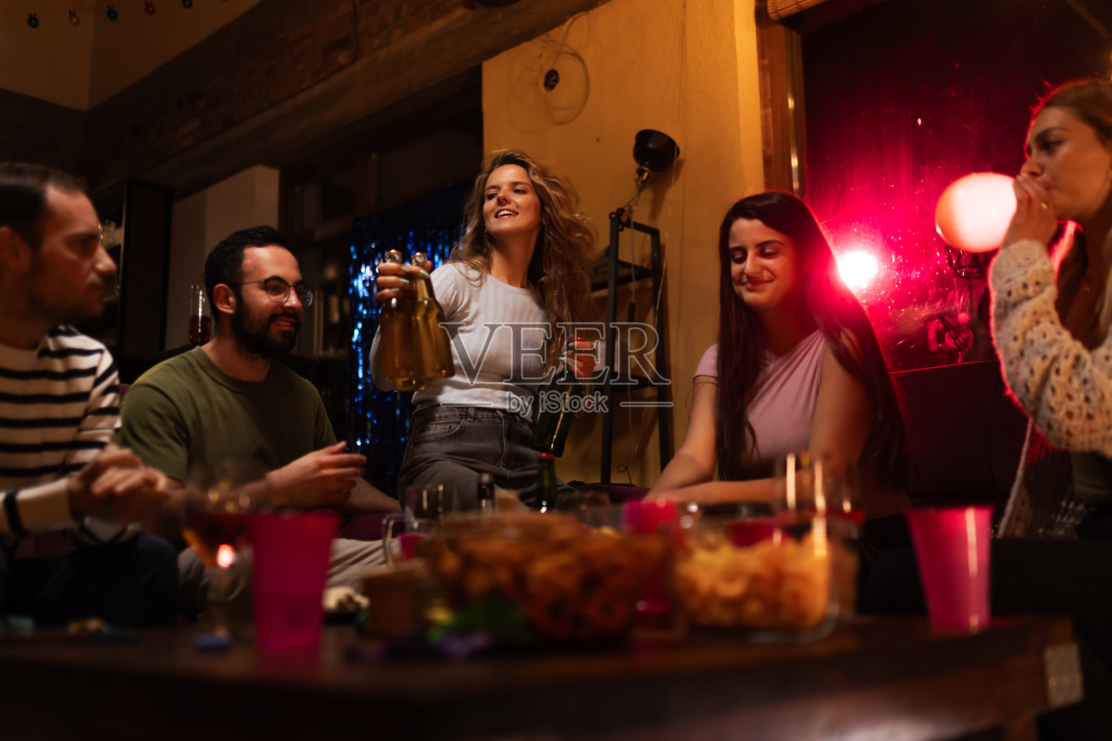 一群朋友在温馨的灯光下享受舒适的聚会照片摄影图片