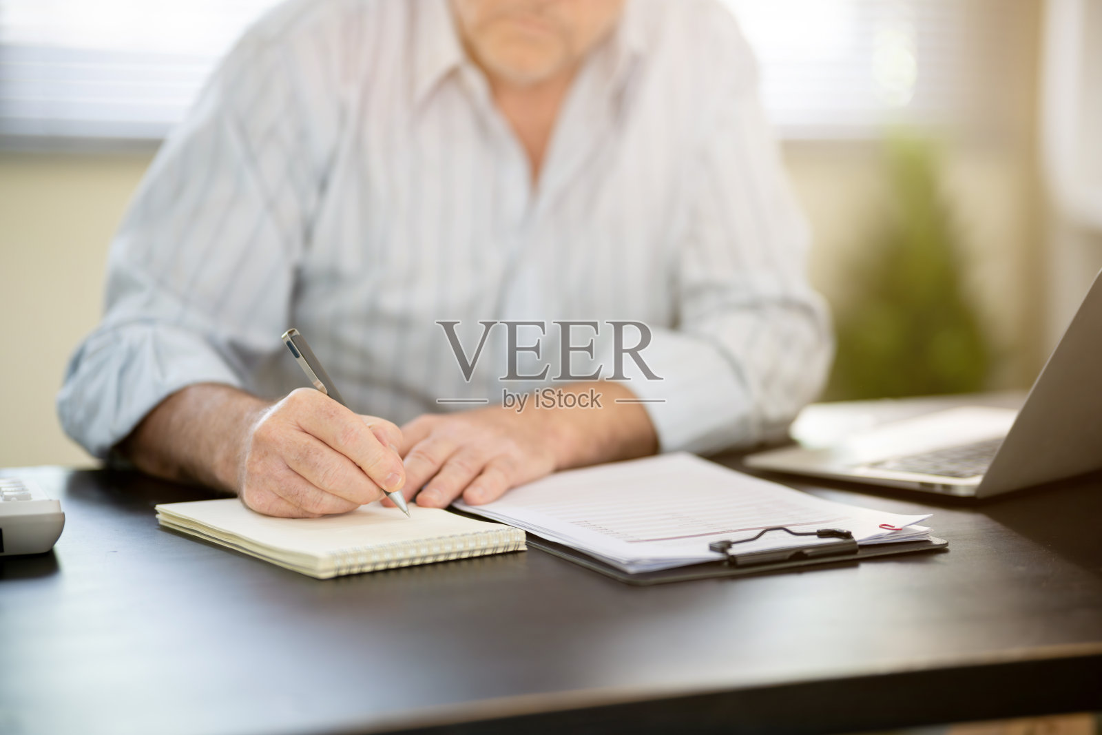 一位商人坐在桌子前工作。照片摄影图片