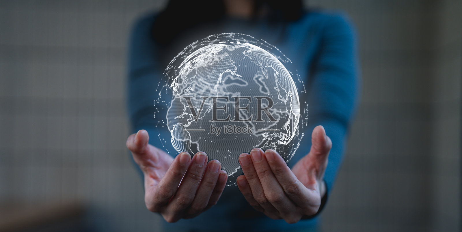 一个人手持地球的数字全息图，象征着科技、全球连接和创新。照片摄影图片