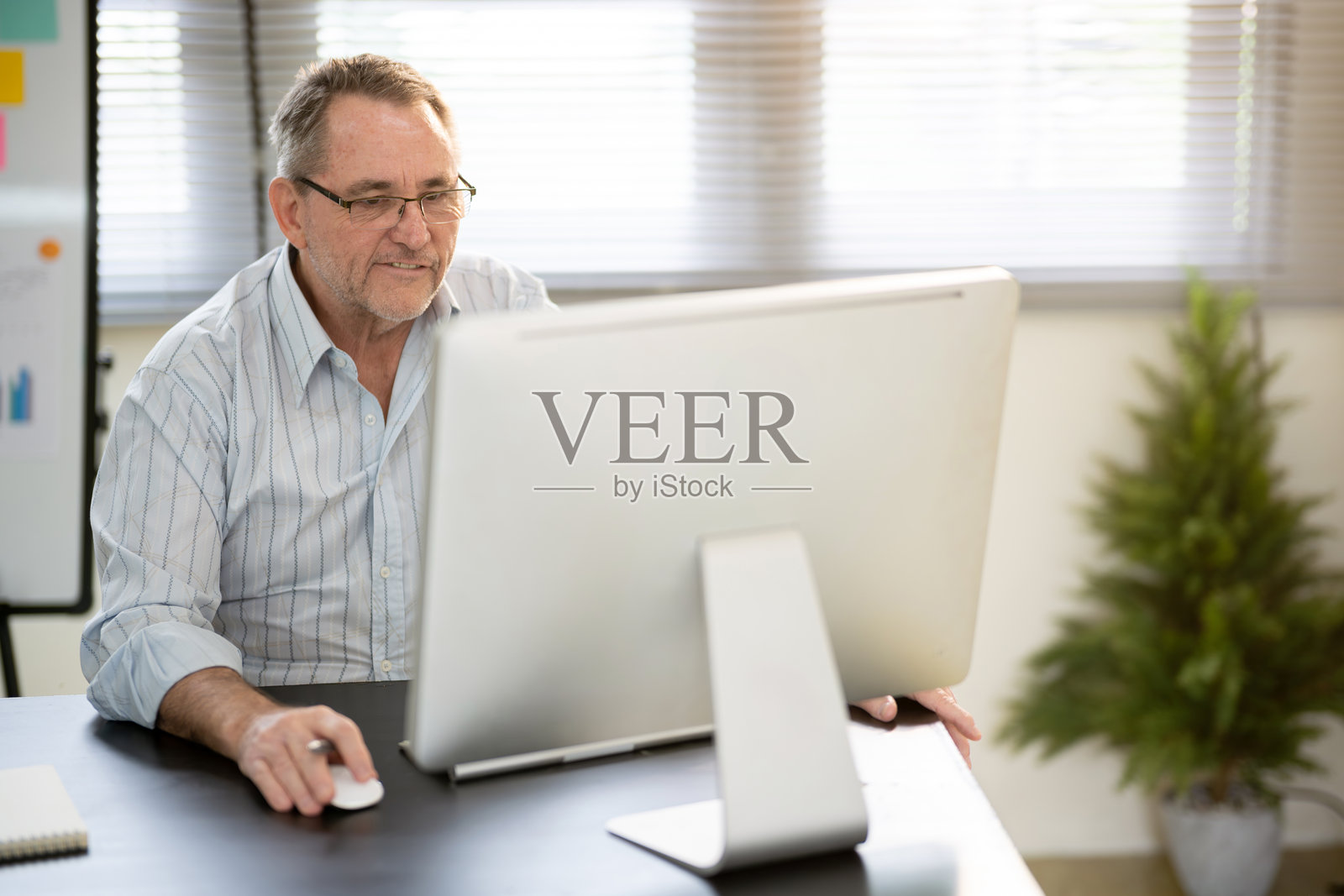 一位商人在桌子前工作。照片摄影图片