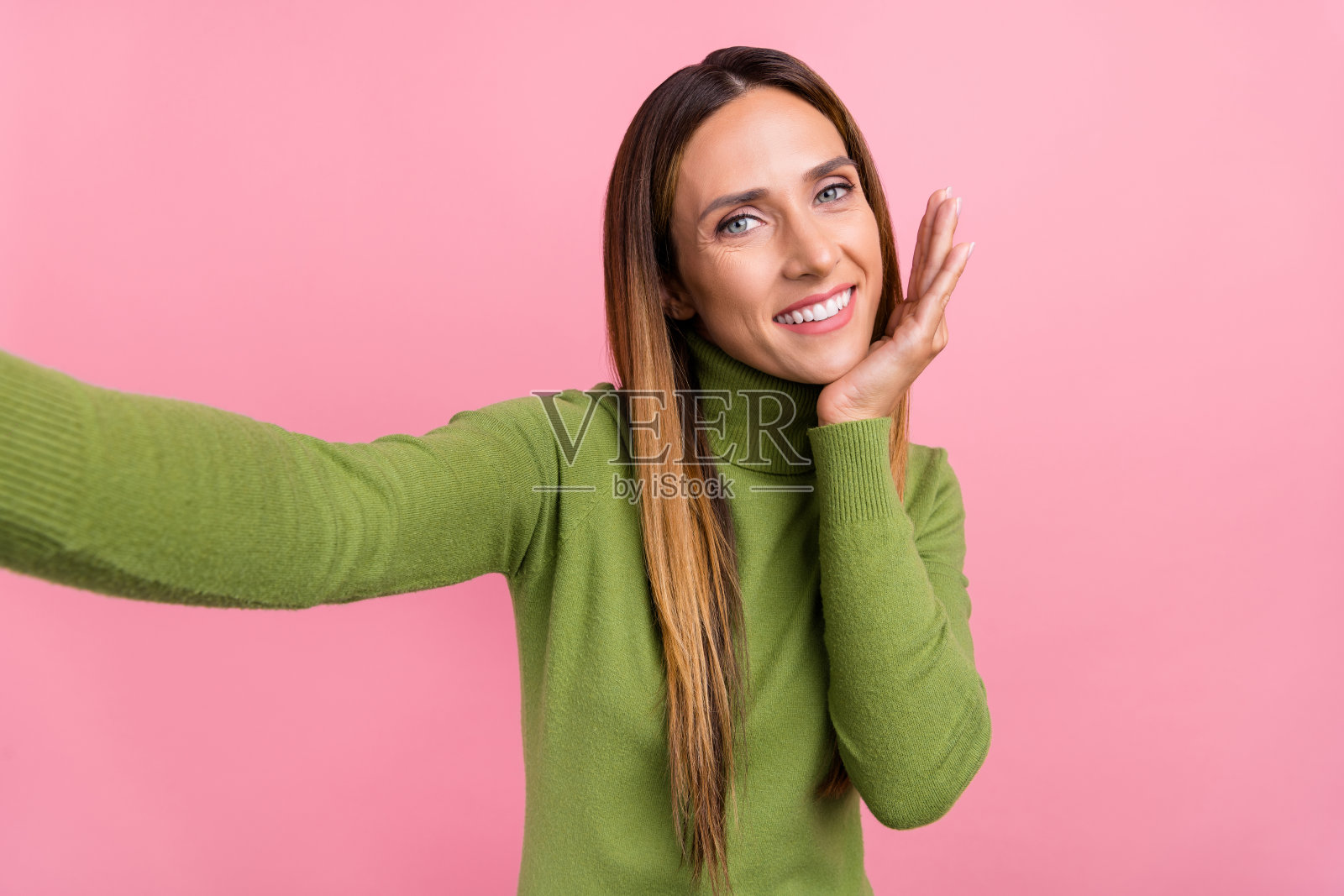 漂亮女士自拍肖像，展现好莱坞微笑植牙，背景为柔和的粉色。照片摄影图片