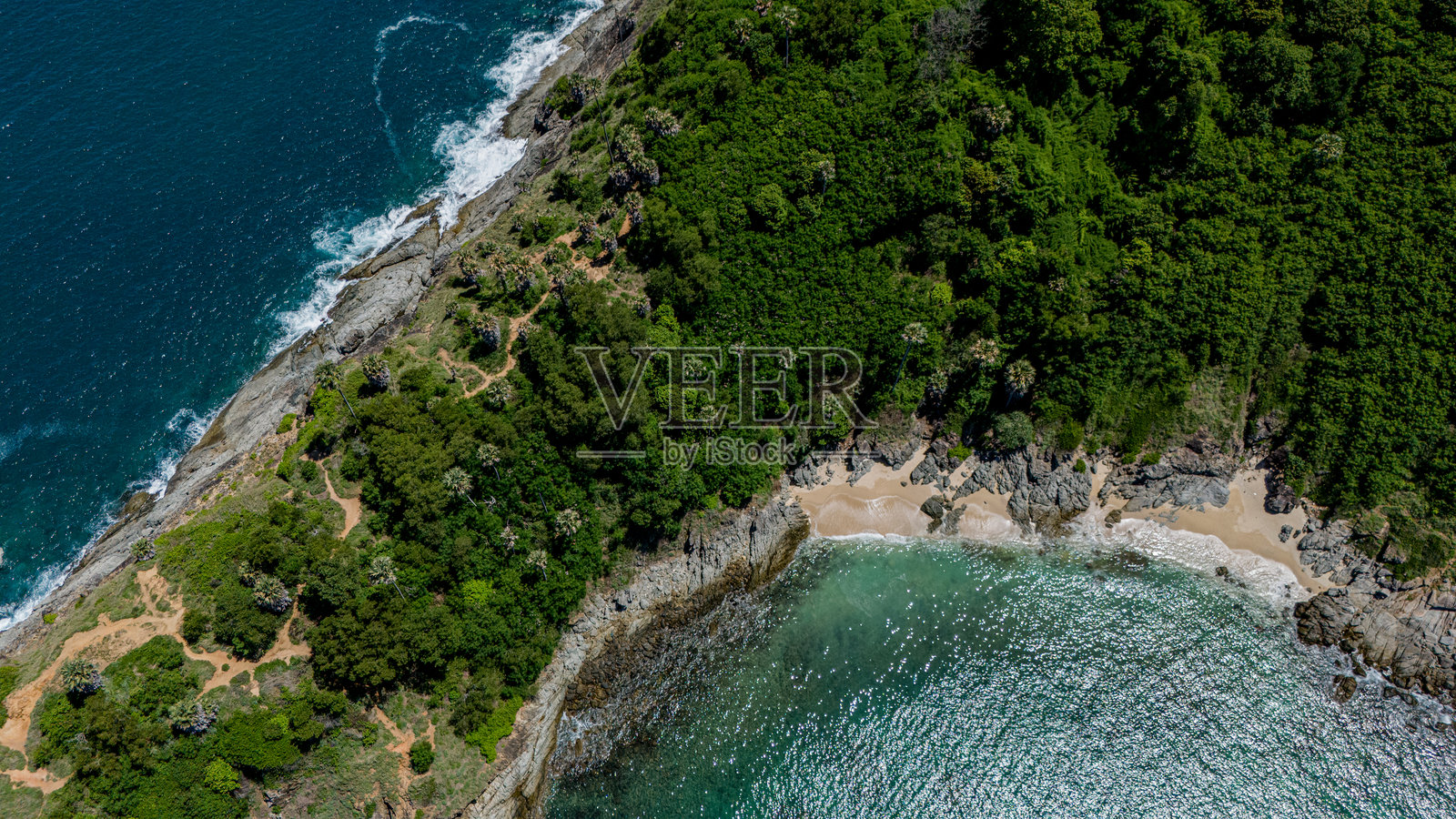 令人惊叹的鸟瞰图展示了一片被郁郁葱葱的树木和海洋环绕的如画海滩。照片摄影图片
