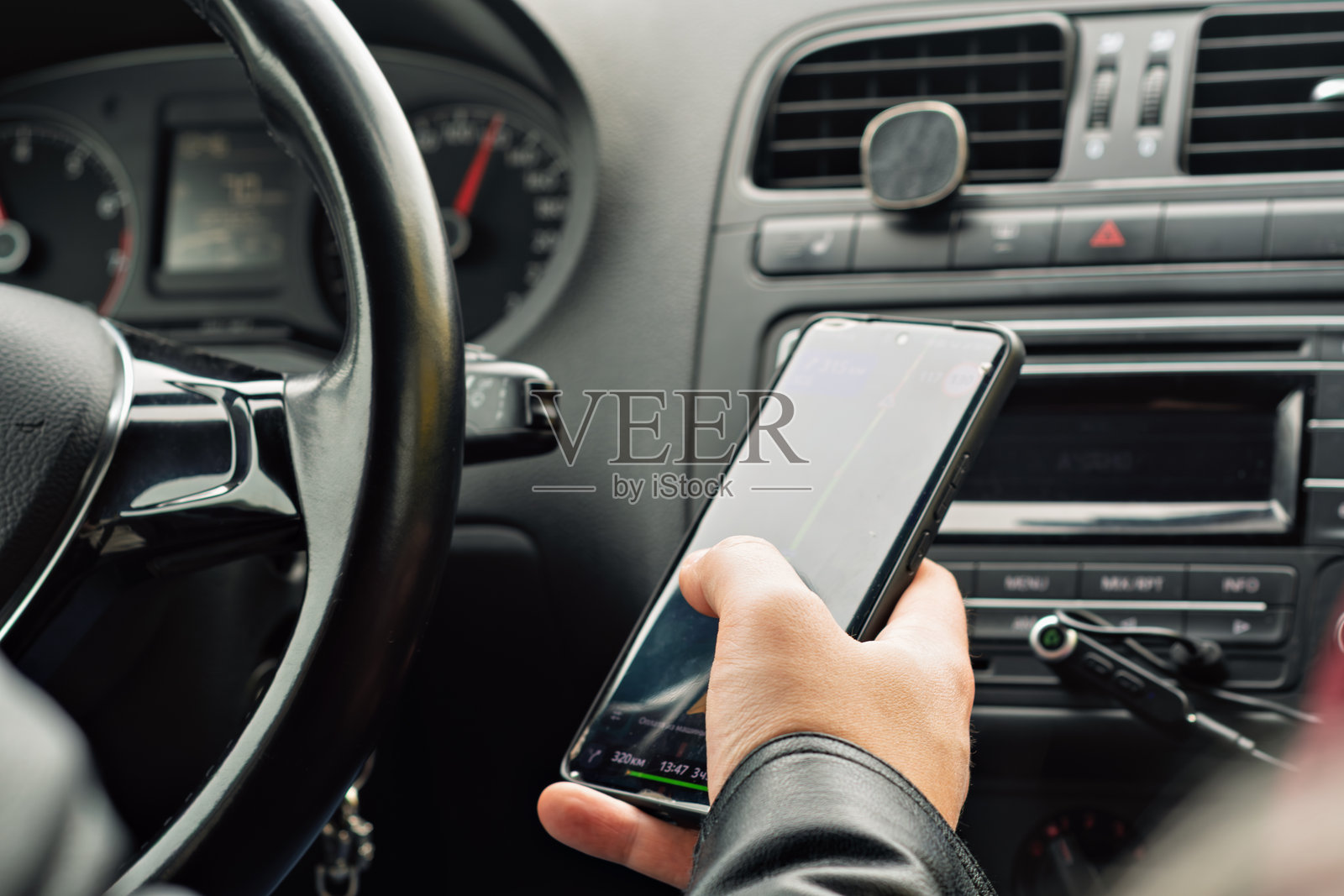 手握智能手机，导航应用程序开启，驾驶中展示日常对数字地图的依赖。照片摄影图片