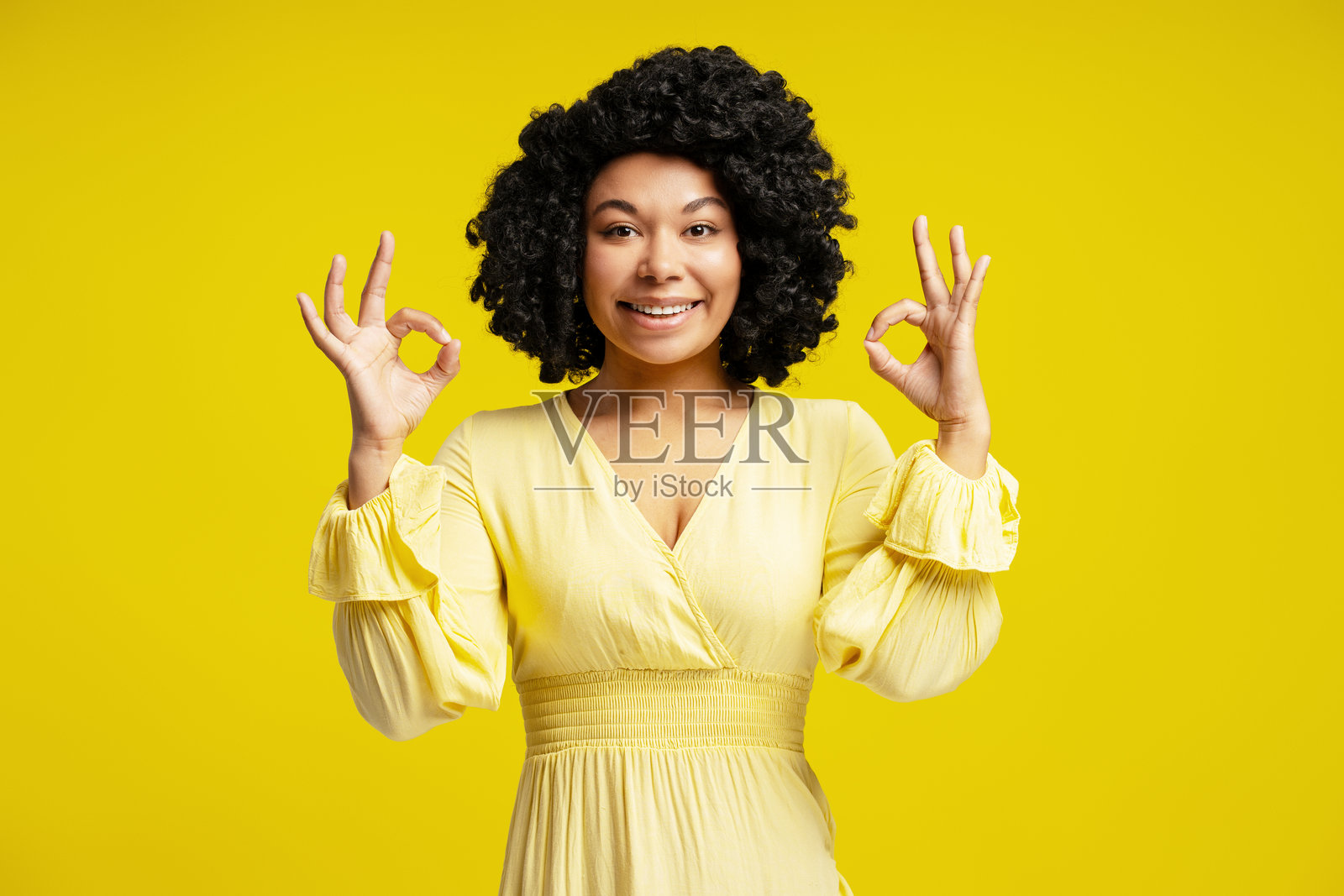 年轻女性用双手做出“好”的手势并微笑照片摄影图片