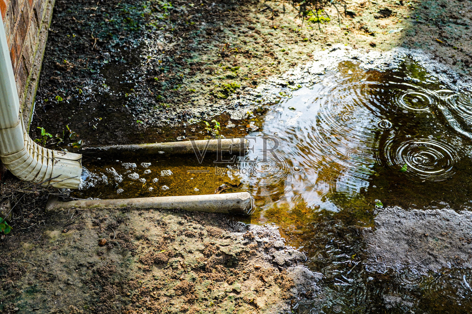 雨天的水沟排水口与水泥溅水块，侵蚀控制照片摄影图片