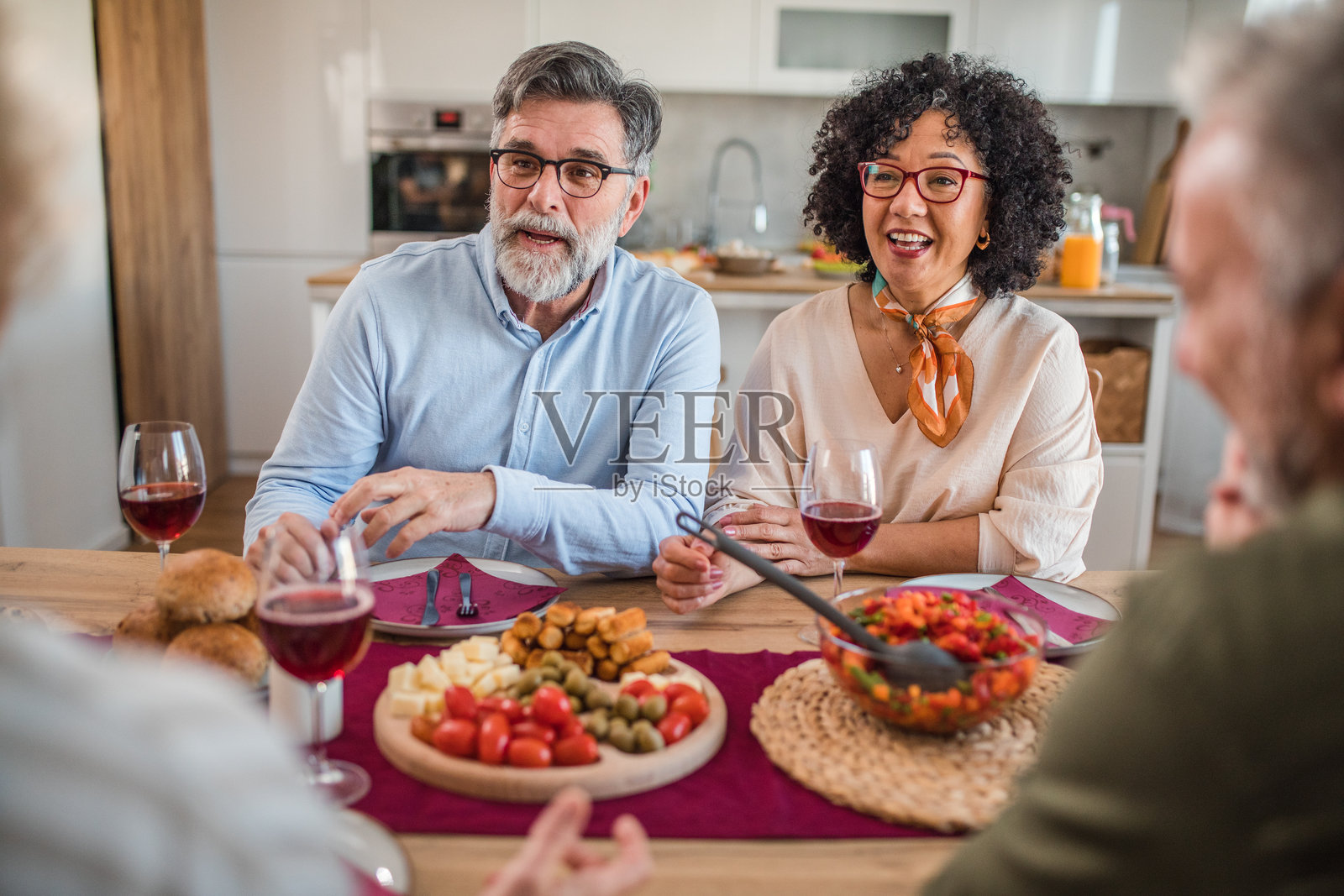 四位成熟的人在餐厅桌子上共进午餐照片摄影图片