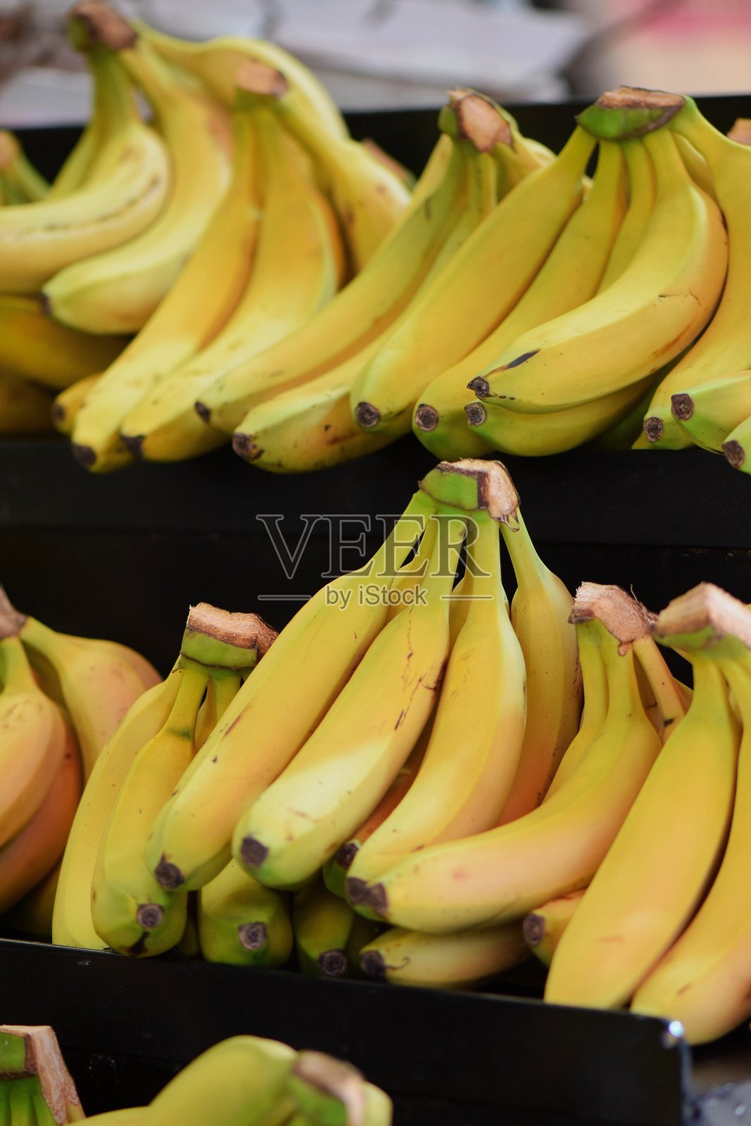 新鲜的黄色香蕉在当地市场上堆放。照片摄影图片