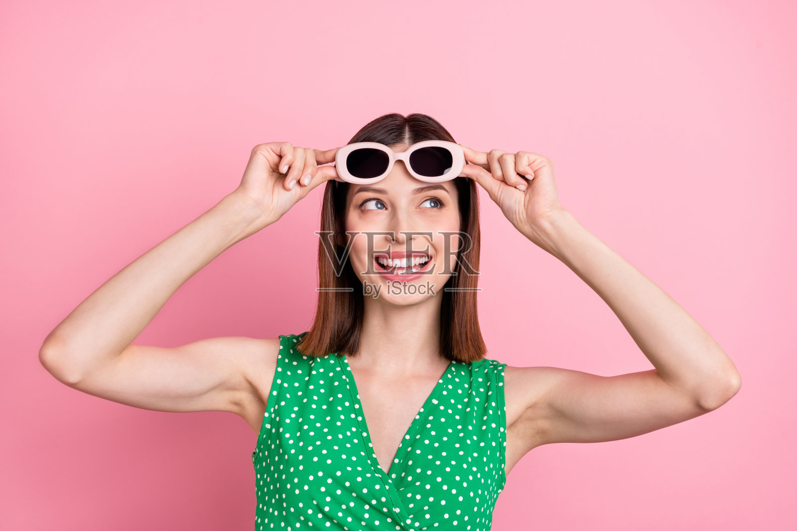 青春洋溢的女孩，带着好奇的目光，空旷的空间，佩戴眼镜，梦想着，背景为粉色。照片摄影图片