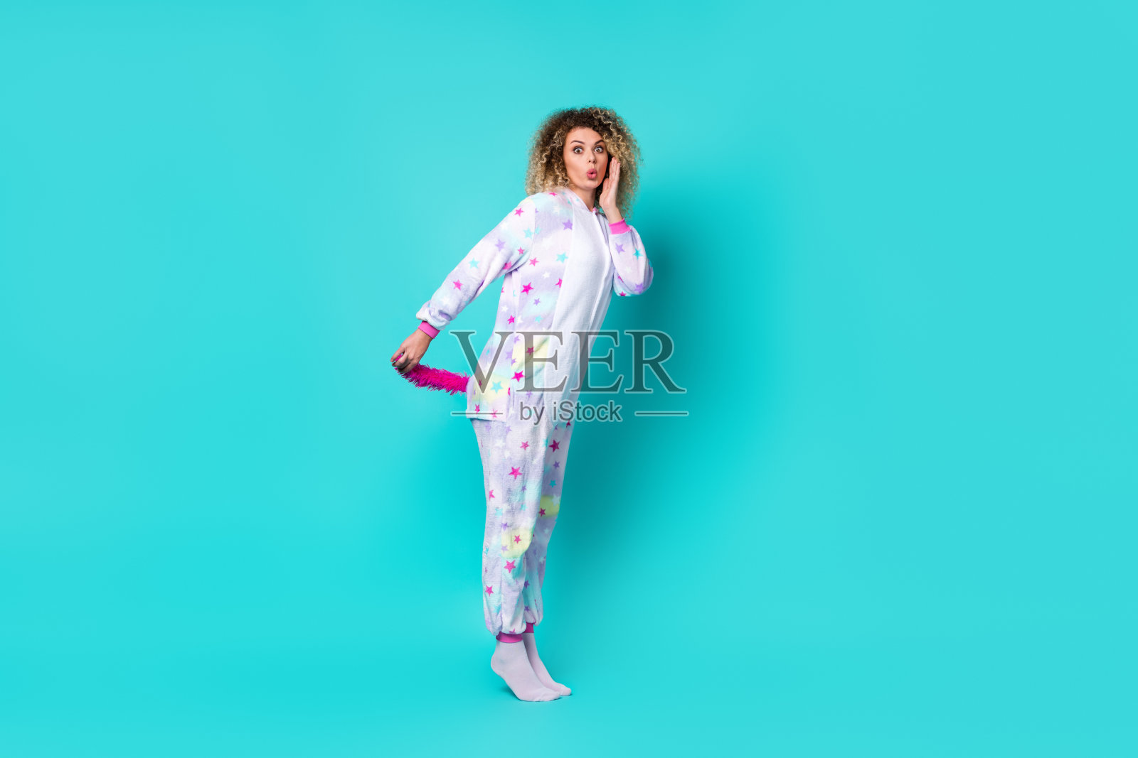 全身照，年轻女士惊讶地穿着尾巴和卡通袜，背景为蓝色。照片摄影图片