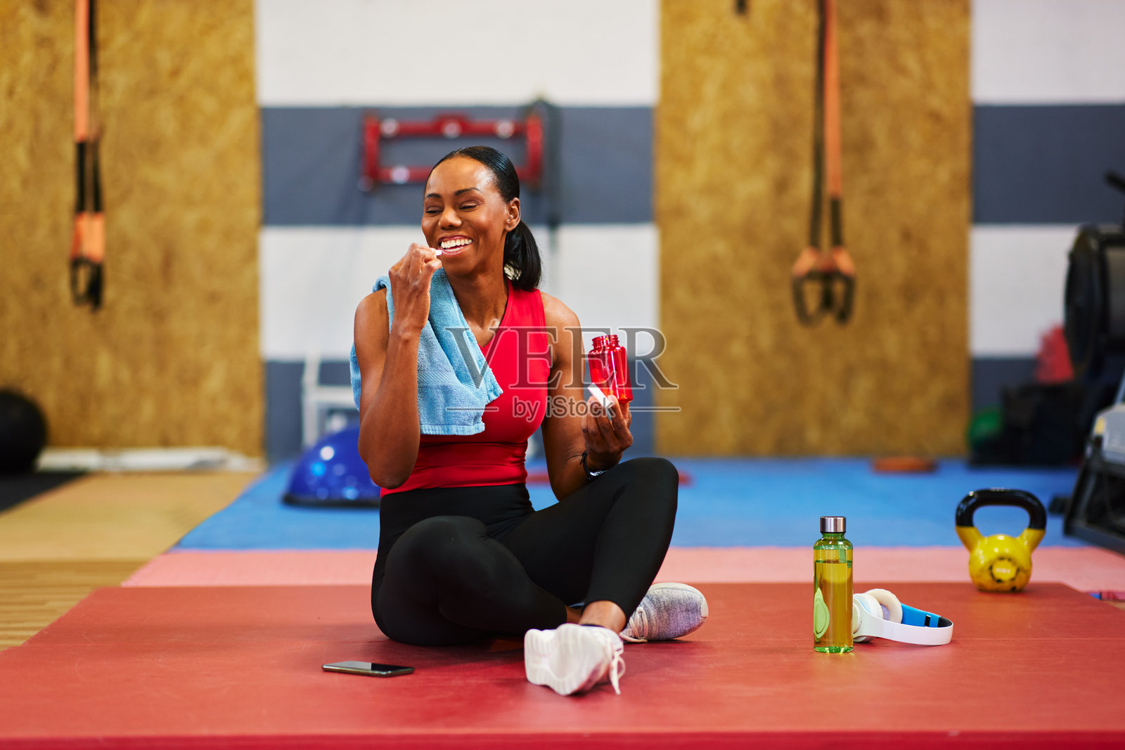 运动员在健身房锻炼后休息，吃能量棒。照片摄影图片