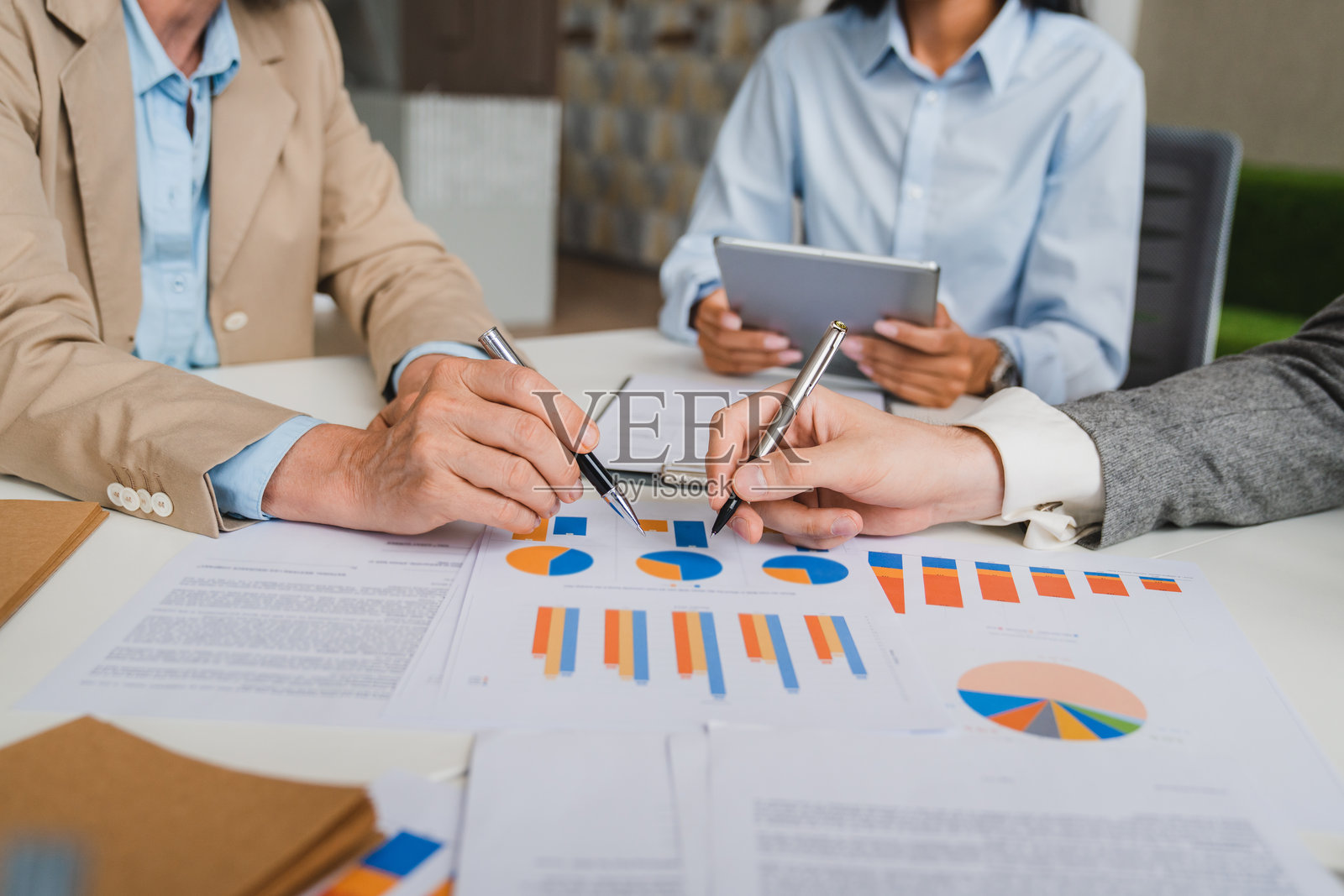 一群商务人士在现代办公室会议室中开会，讨论、分析图表和财务数据，共同规划市场项目的特写镜头。团队合作概念。照片摄影图片