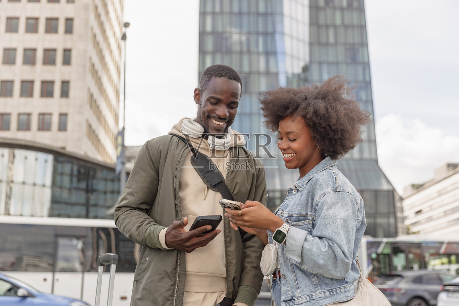 一对游客在城市中推着行李箱前往酒店照片摄影图片