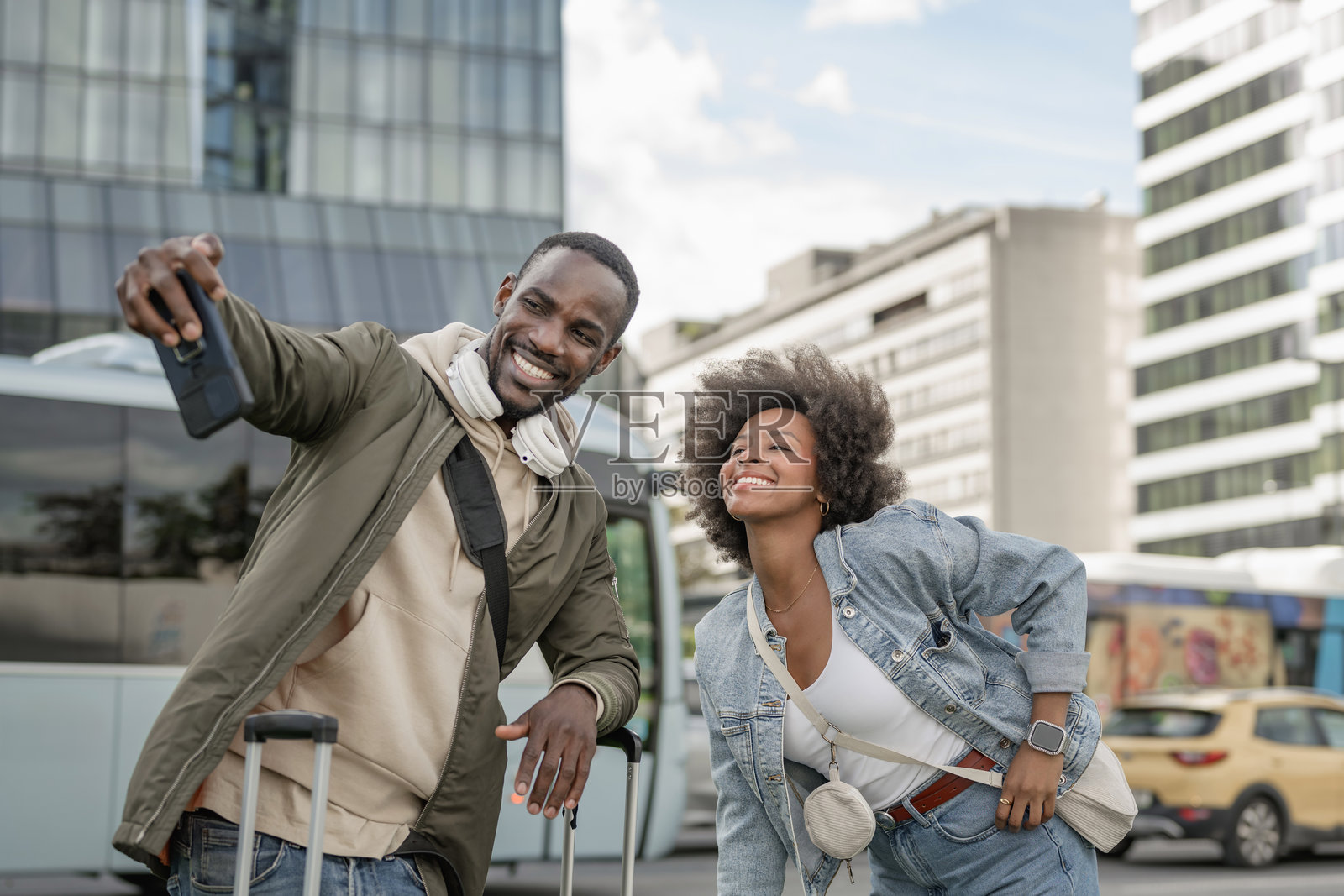 一对游客情侣在繁忙的城市街道上与摩天大楼合影留念，享受快乐时光。照片摄影图片