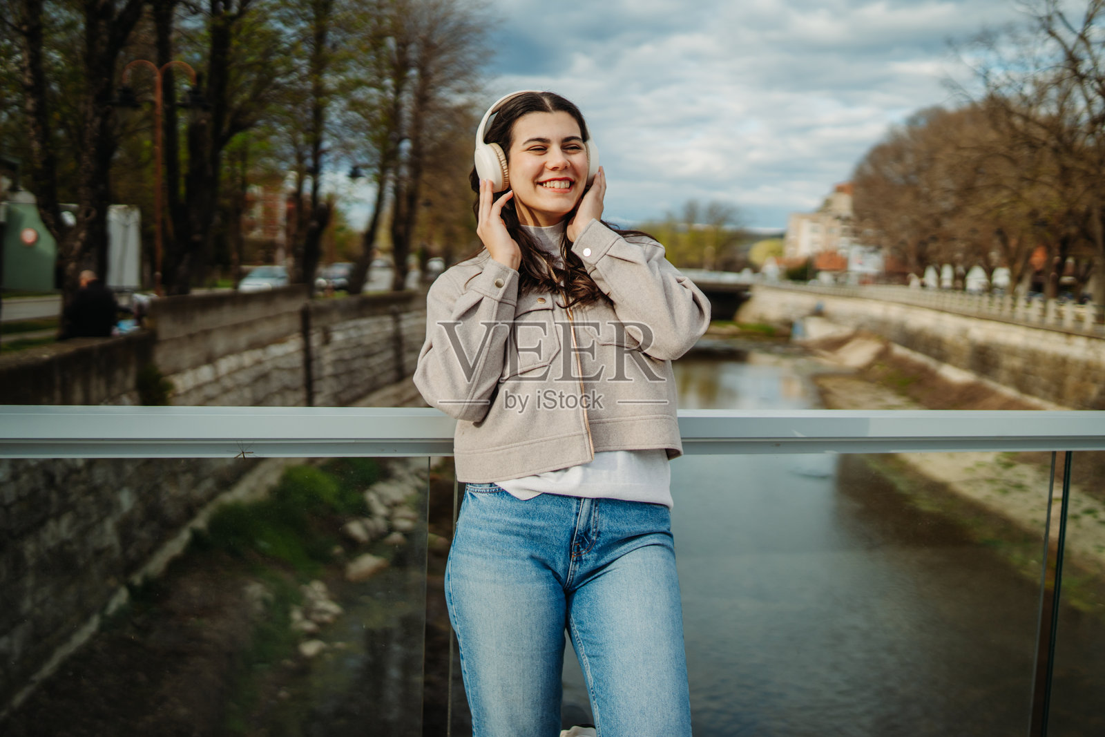 年轻的白人女性戴着无线耳机听音乐照片摄影图片