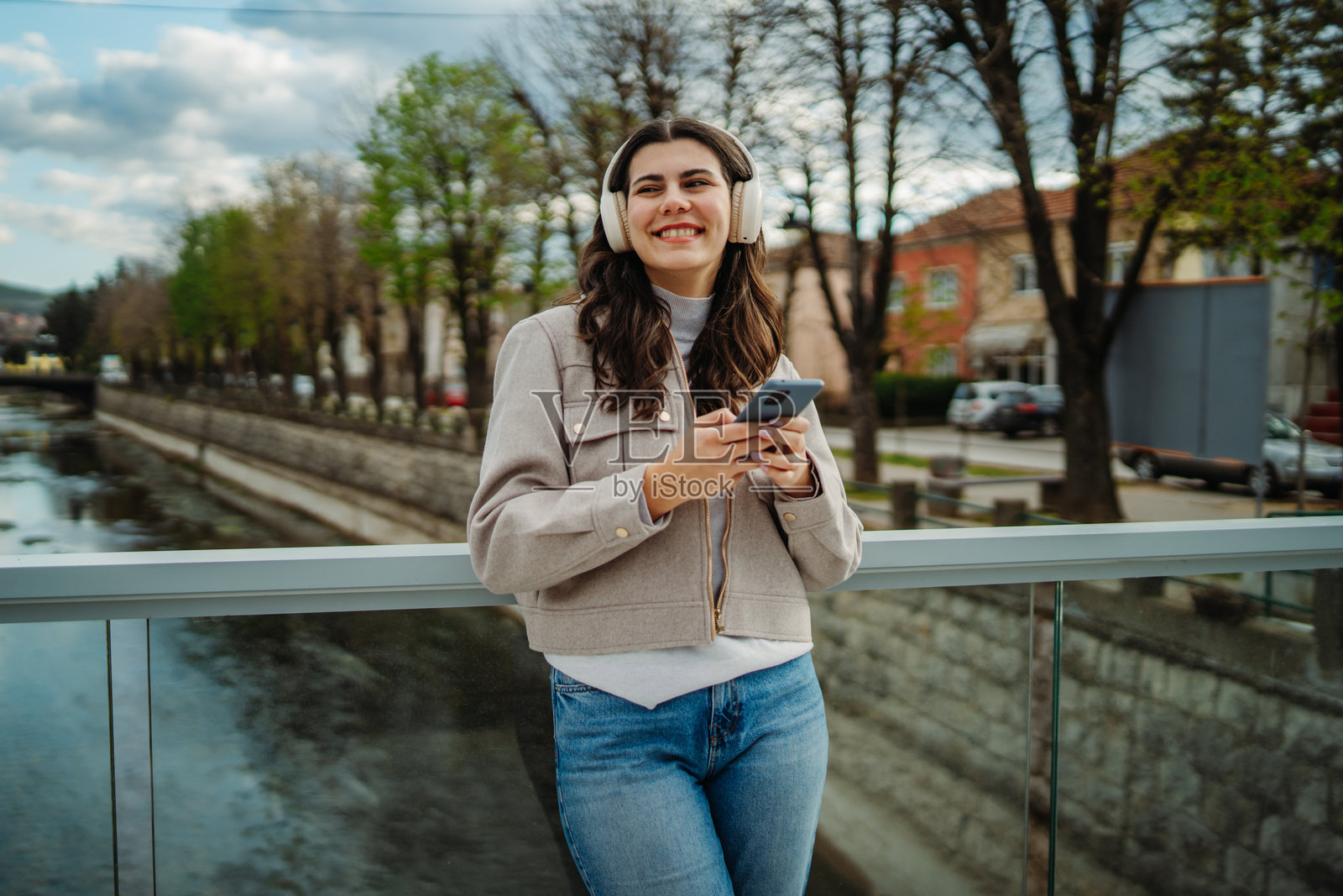 年轻的白人女性戴着无线耳机听音乐照片摄影图片