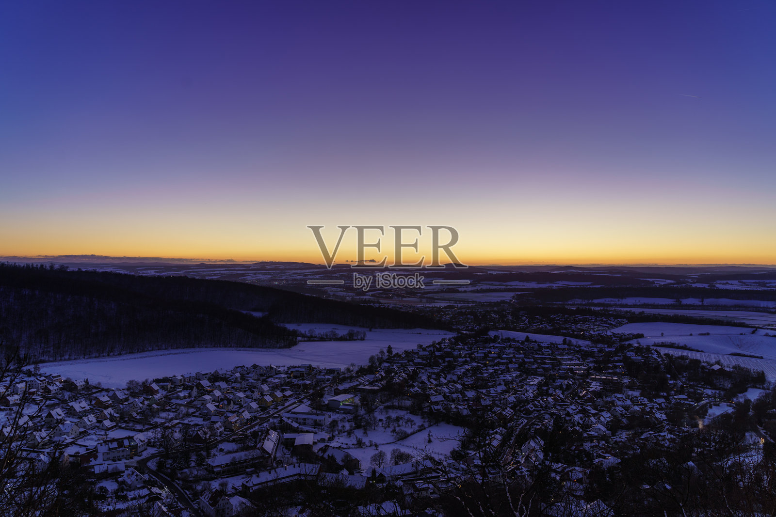 金色日落为雪-covered小镇洒下温暖的光辉照片摄影图片