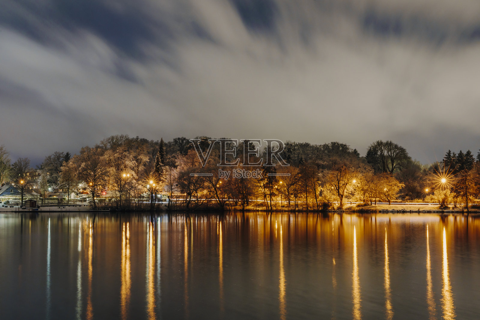 夜晚湖泊的景色，城市灯光倒映在水面上照片摄影图片