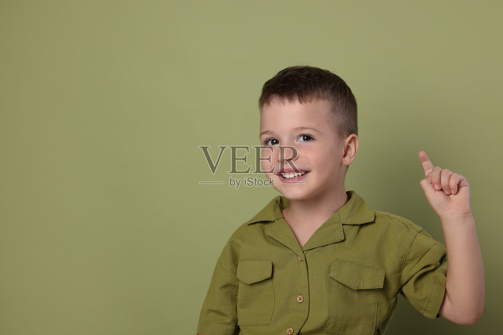 可爱小男孩的肖像，绿色背景，留有文字空间照片摄影图片