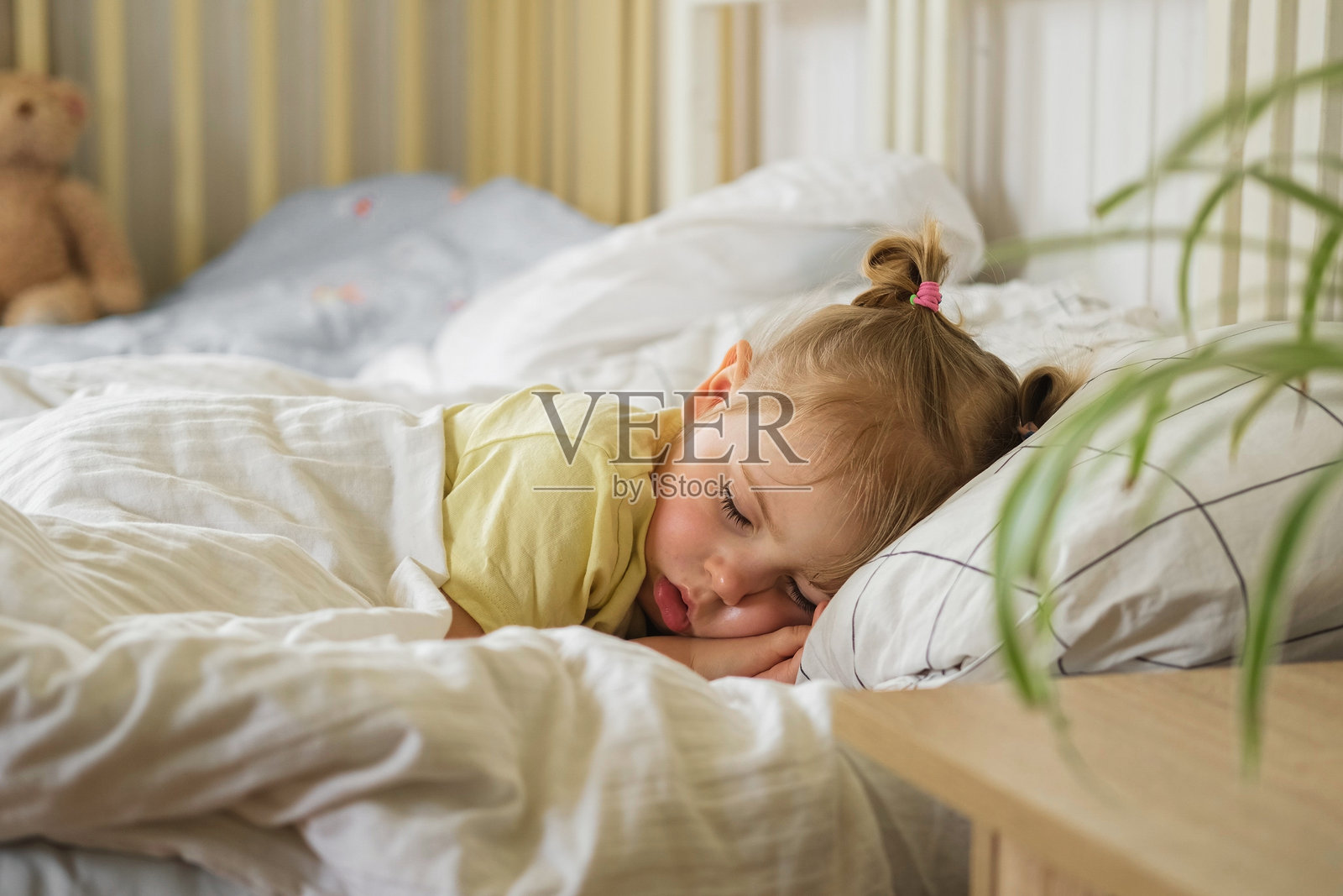 安静可爱的婴儿在家里的床上睡觉。沉睡的小女孩。两岁的小女孩在家居室内背景中安静地入睡。宁静的梦境。可爱的面孔特写。孩子深沉的睡眠。照片摄影图片