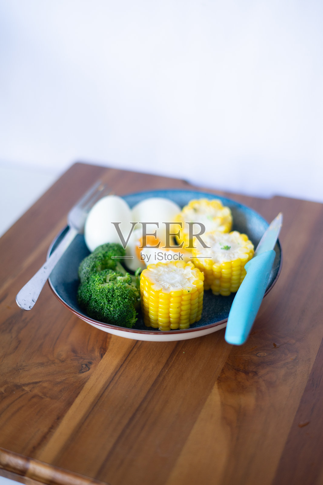 木桌上的健康餐：西兰花、鸡蛋和玉米照片摄影图片