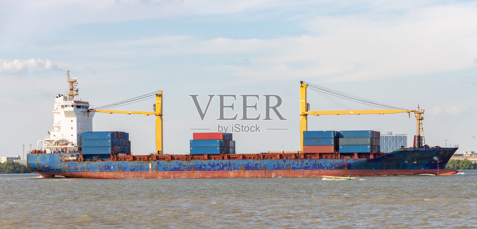 装载集装箱的货轮在海岸旁航行照片摄影图片