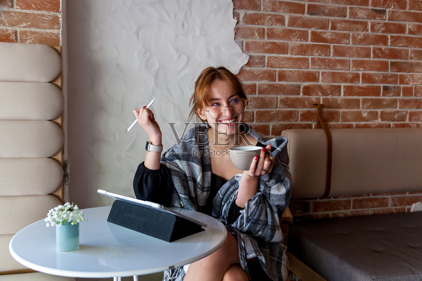 在舒适的咖啡馆里，创意女性正在使用平板电脑和享用咖啡照片摄影图片