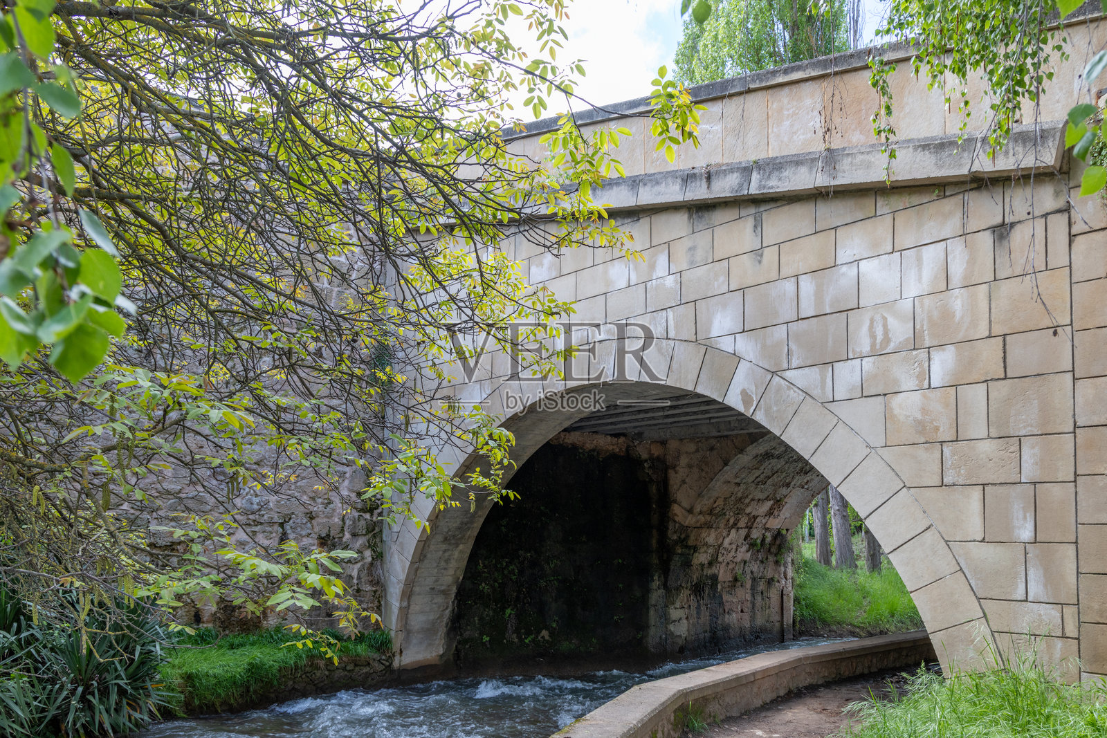 西班牙特里略镇的瀑布流经该镇，游客在特里略地区漫步。照片摄影图片