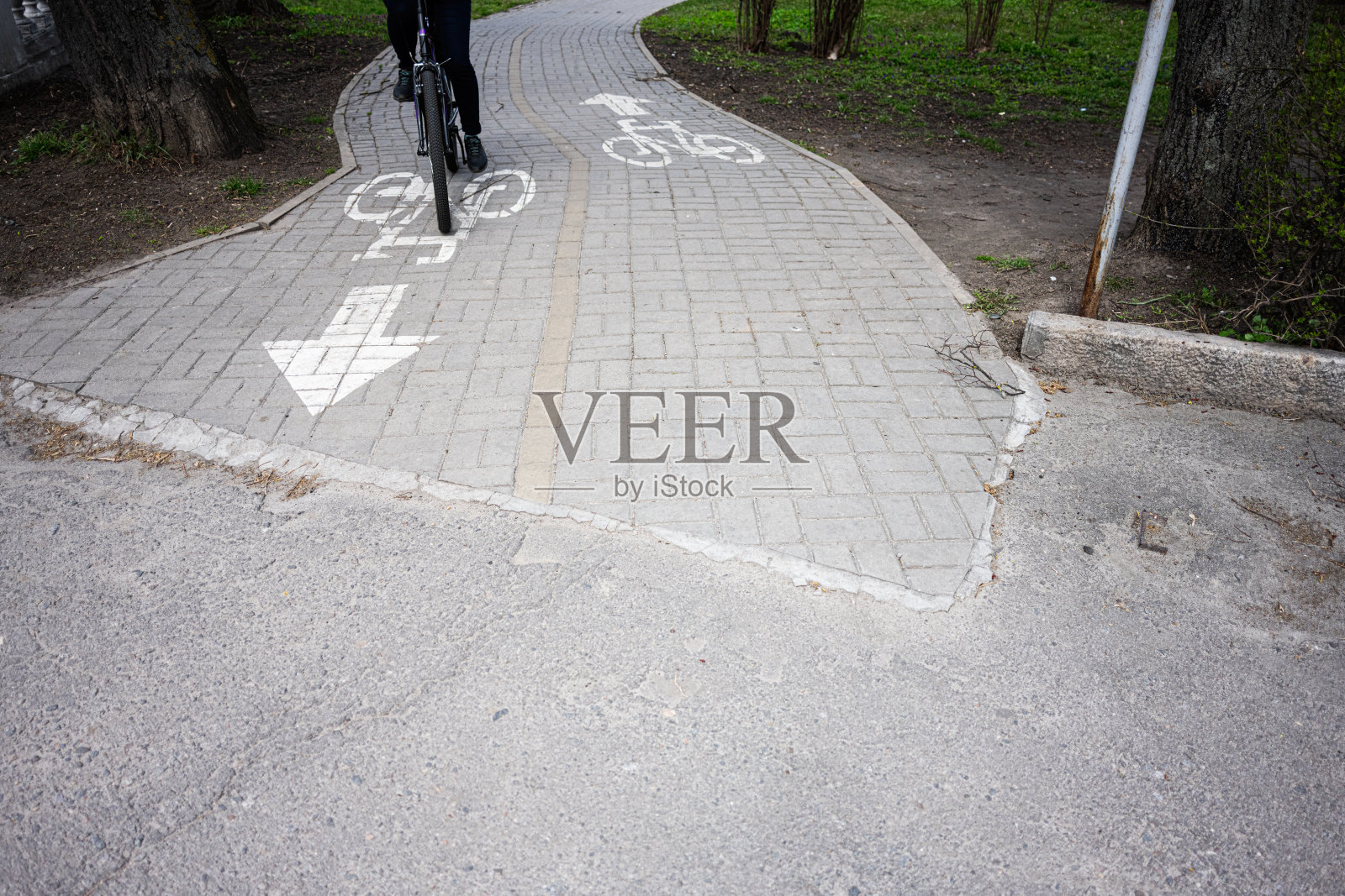 城市铺设的自行车道上骑行的自行车手，带有方向标记照片摄影图片