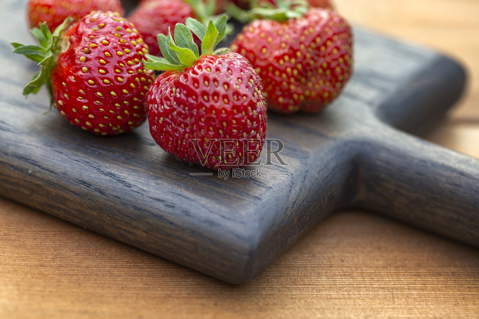 成熟多汁的草莓放在木桌上。富含纤维、维生素和抗氧化剂的健康食品。素食。照片摄影图片