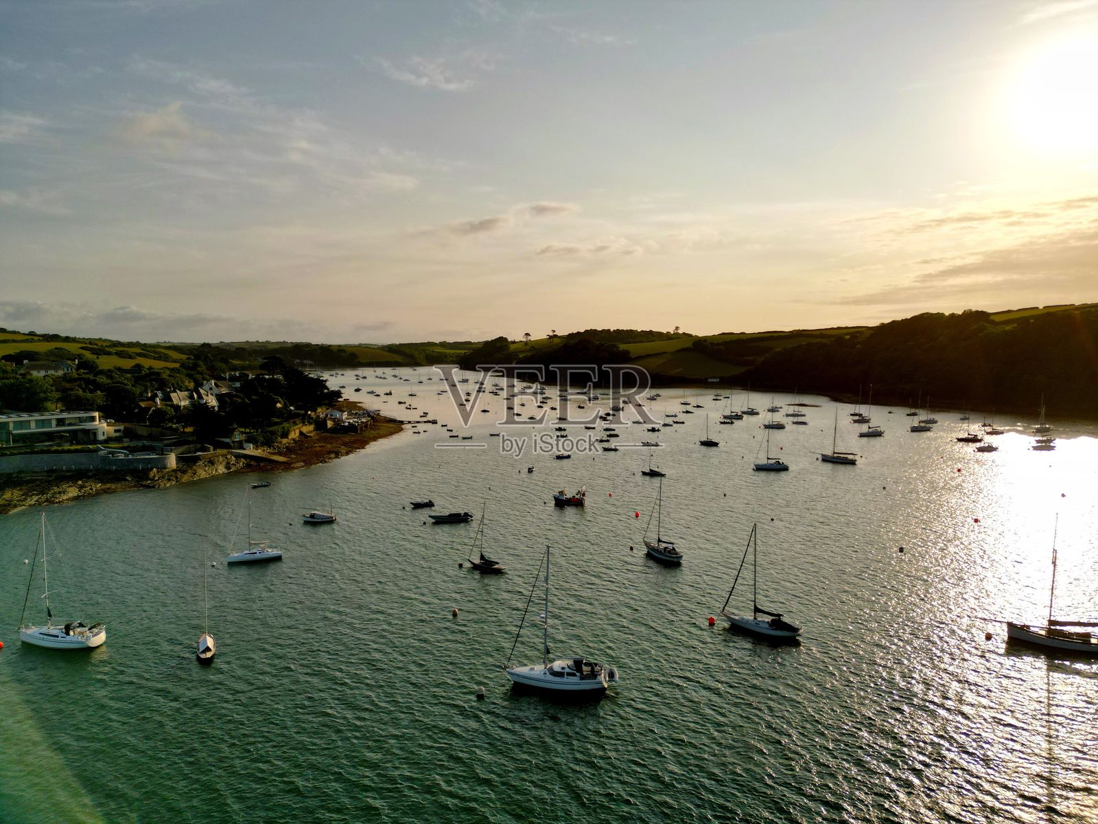 宁静的海岸风景，停泊的船只与日落。照片摄影图片